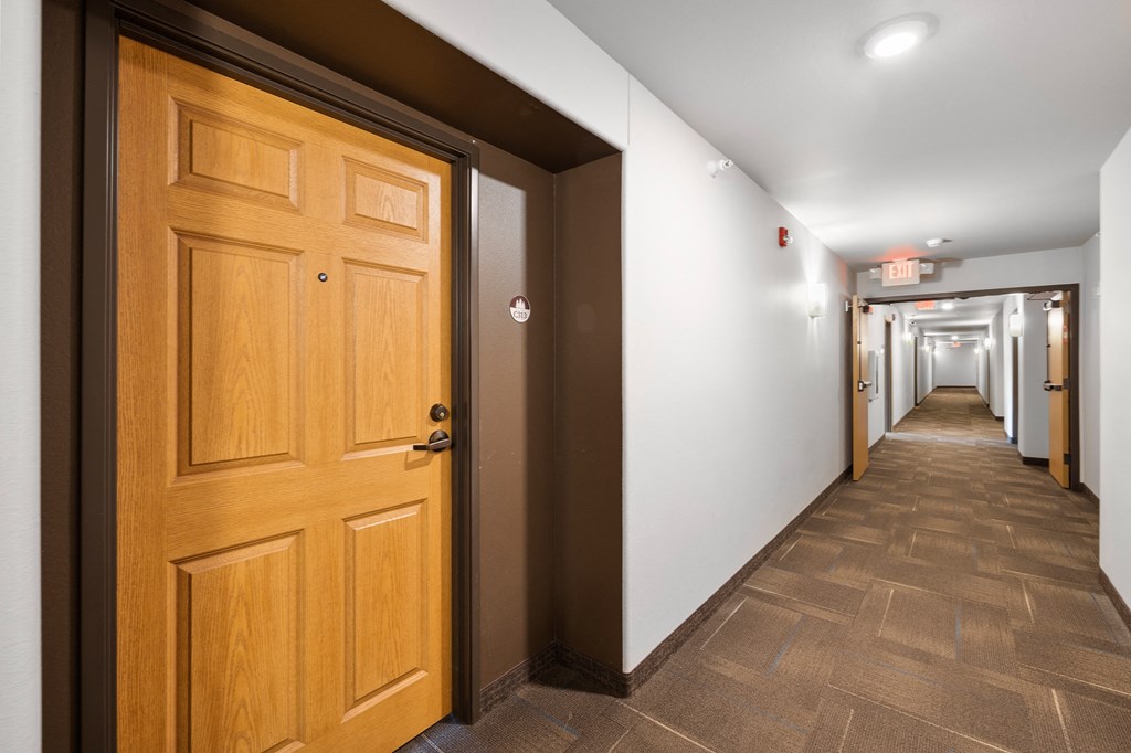 a view down a hall with a wooden door in the foreground