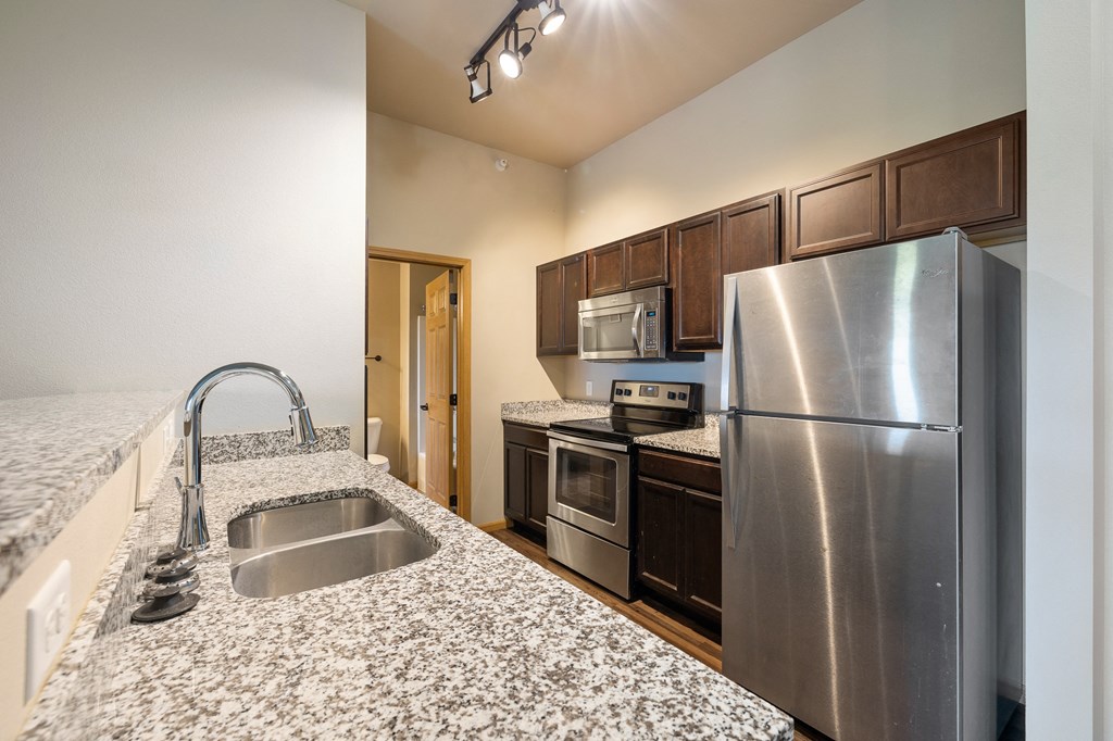 a kitchen with granite countertops and stainless steel appliances