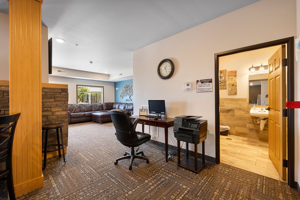 a living room with a couch and a desk with a computer