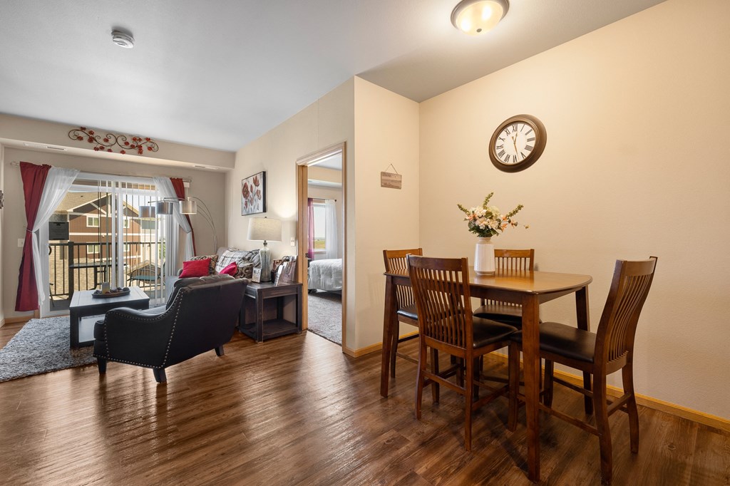a living room and dining room with hardwood floors and a large window