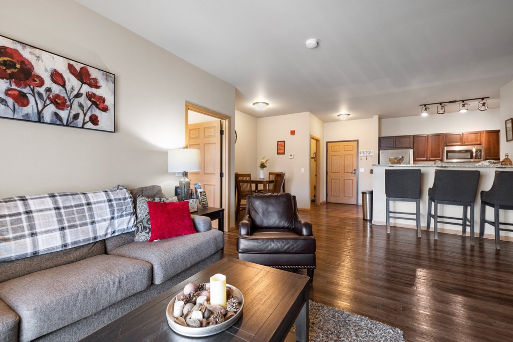 a living room with a couch and chair and a table with a bowl of candles on it