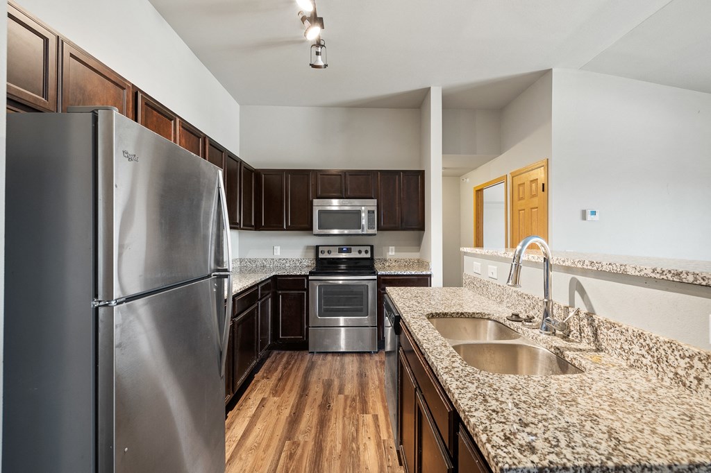a kitchen with granite countertops and stainless steel appliances