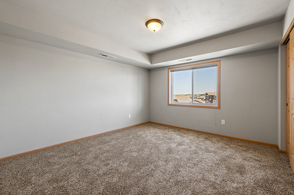 a bedroom with grey walls and carpet