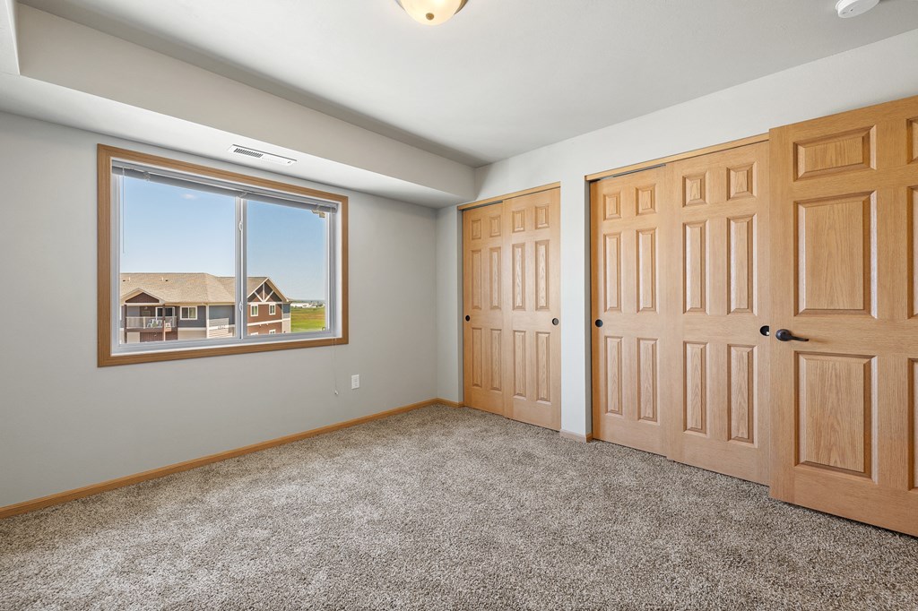 a bedroom with two doors and a large window