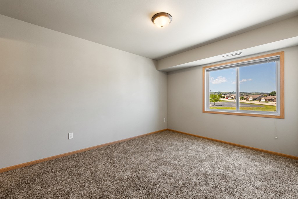 a bedroom with a large window and carpet