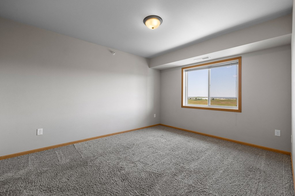 a bedroom with gray walls and a window