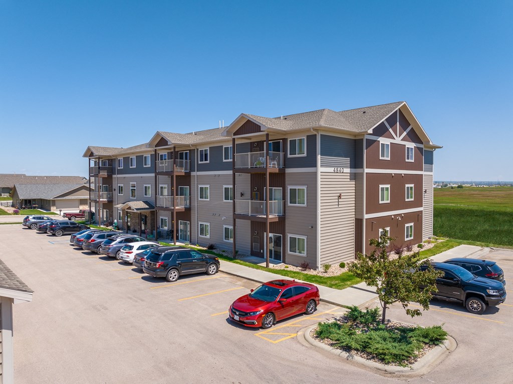 a large apartment building with a parking lot in front of it