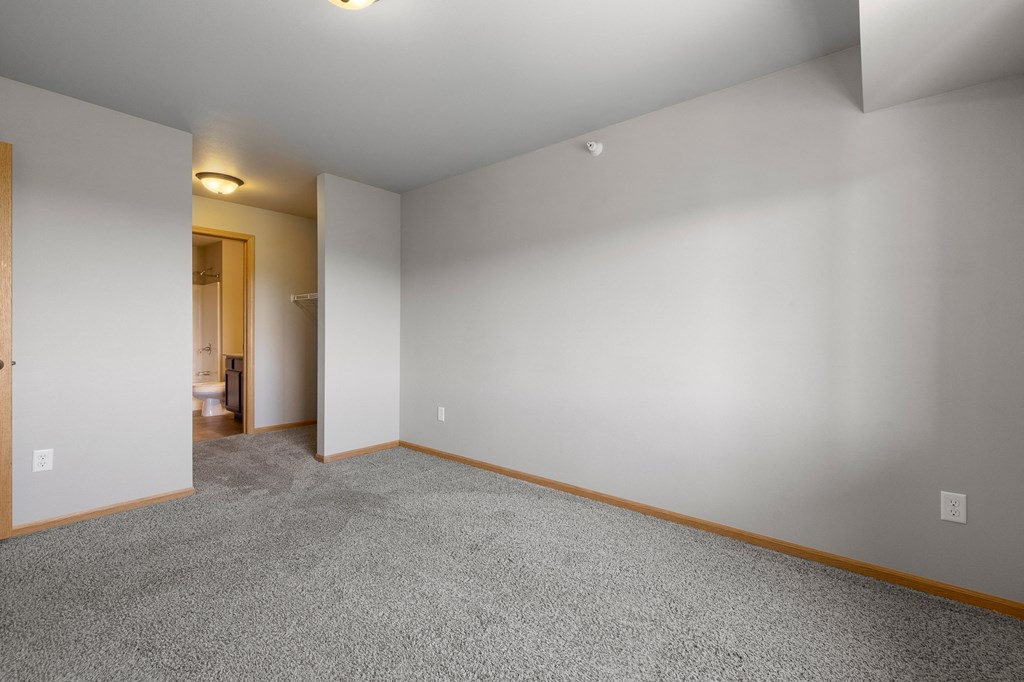 a bedroom with grey carpet and white walls