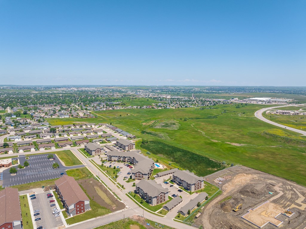 an aerial view of a city with a green field in the background