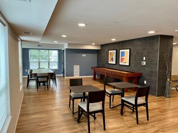 a room with a table and chairs and a large window