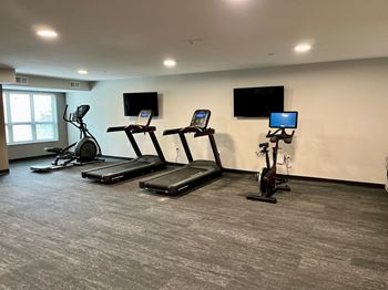 A gym with treadmills, elliptical machines, and exercise bikes.