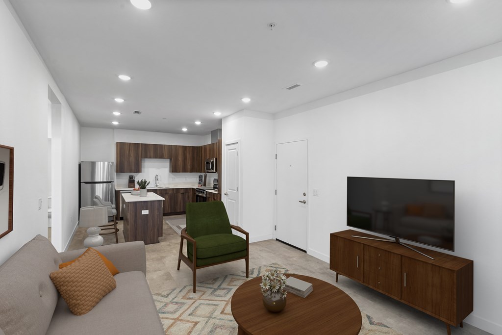 A living room with a grey couch, a green chair, a wooden coffee table and a television.