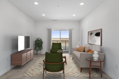 A living room with a green chair and a couch.