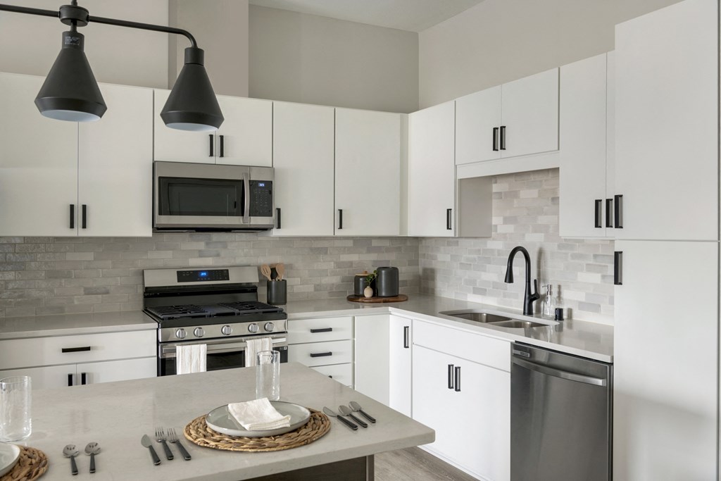 a kitchen with white cabinets and stainless steel appliances