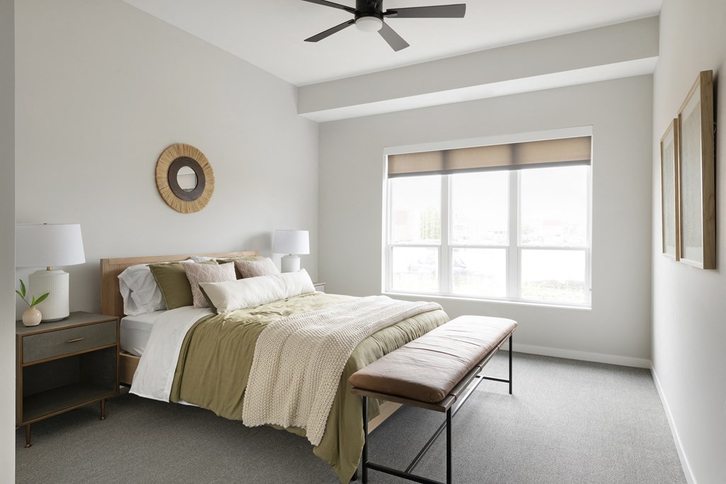 a bedroom with a bed and a ceiling fan