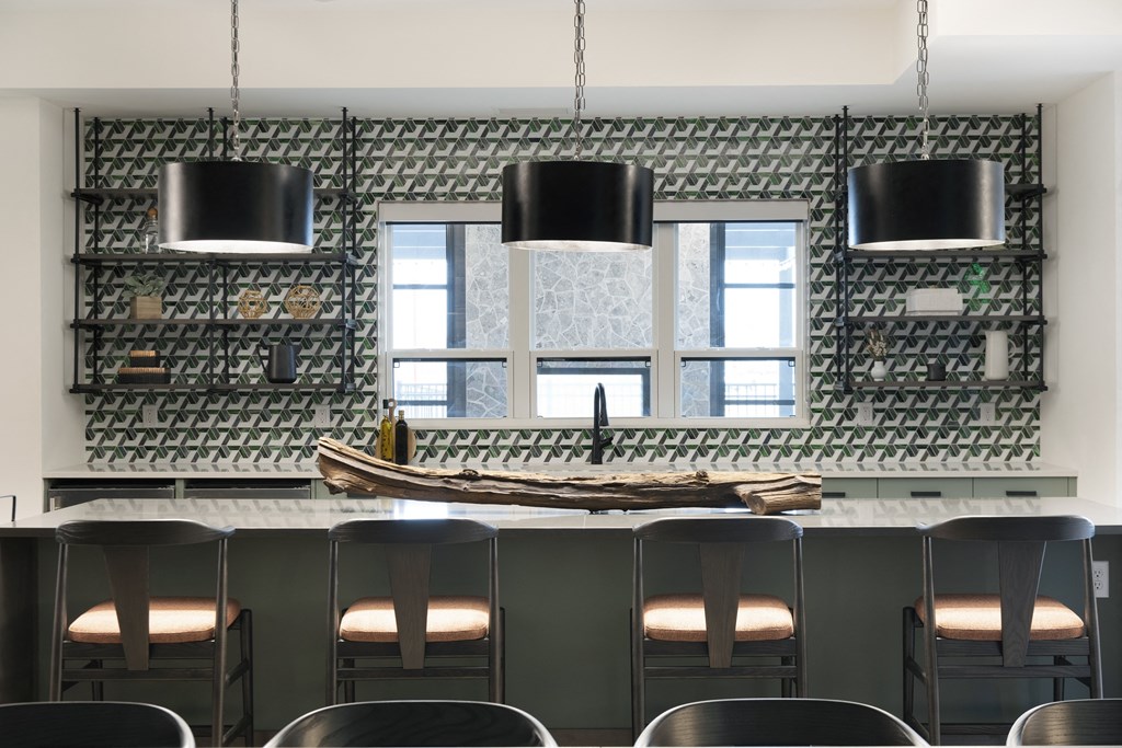 a bar with black stools in front of a window and a boat on top