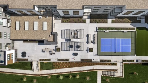 A modern building with a pool and a tennis court.
