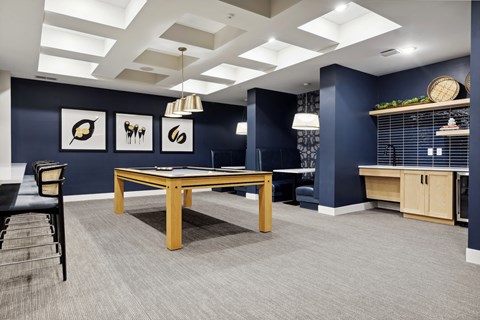 A room with a table and chairs and pictures on the wall.