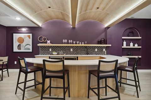 A kitchen with purple walls and a white counter.