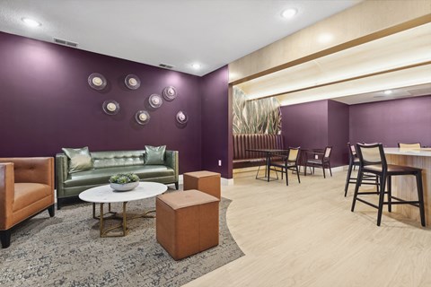 A living room with a green couch, a white coffee table, and a wooden floor.