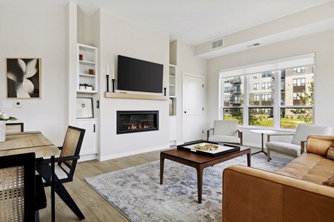 A living room with a fireplace, a couch, a chair, a coffee table, and a television.