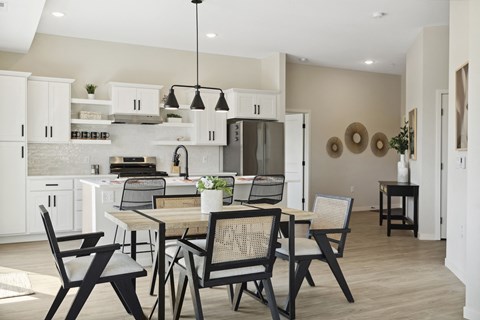 A modern kitchen with a dining table and chairs.