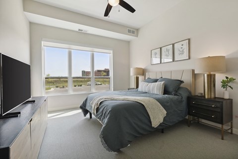 A bedroom with a large bed and a flat screen TV.