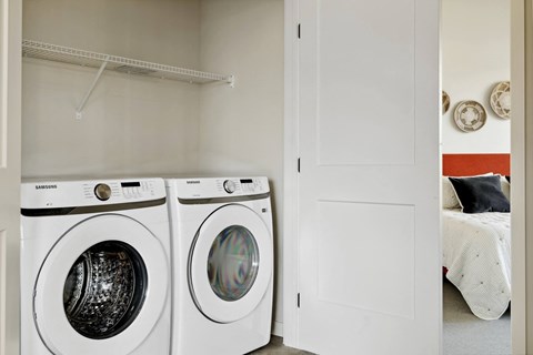Two white front loading washing machines in a laundry room.