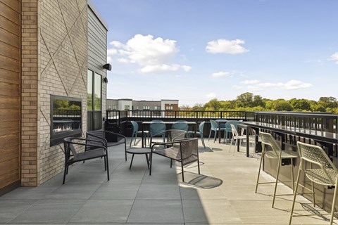 A patio with chairs and a table with a TV on the wall.