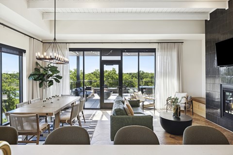 A modern living room with a dining table and chairs.
