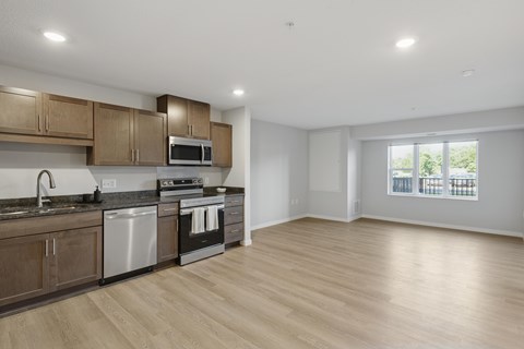 A kitchen with wooden cabinets and a stainless steel dishwasher.