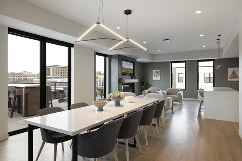 A modern dining room with a long table and chairs.