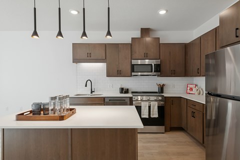 A modern kitchen with wooden cabinets and stainless steel appliances.