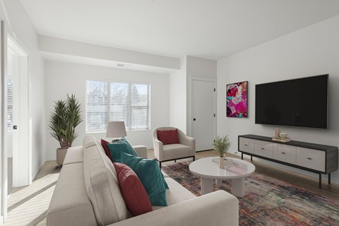 A living room with a white couch, a white coffee table, and a black television on the wall.