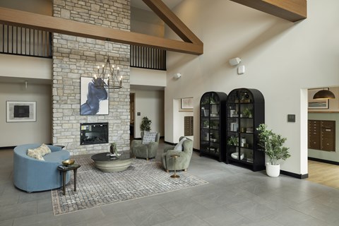A living room with a stone fireplace and a large painting above it.