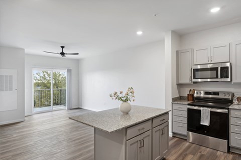 A kitchen with a fan on the ceiling and a stove with an oven.