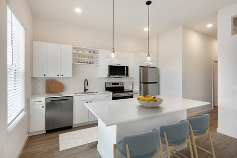 A modern kitchen with white cabinets and a large island.