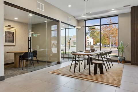 A modern dining room with a glass table and chairs.