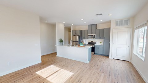 A kitchen with a white counter and wooden floors.