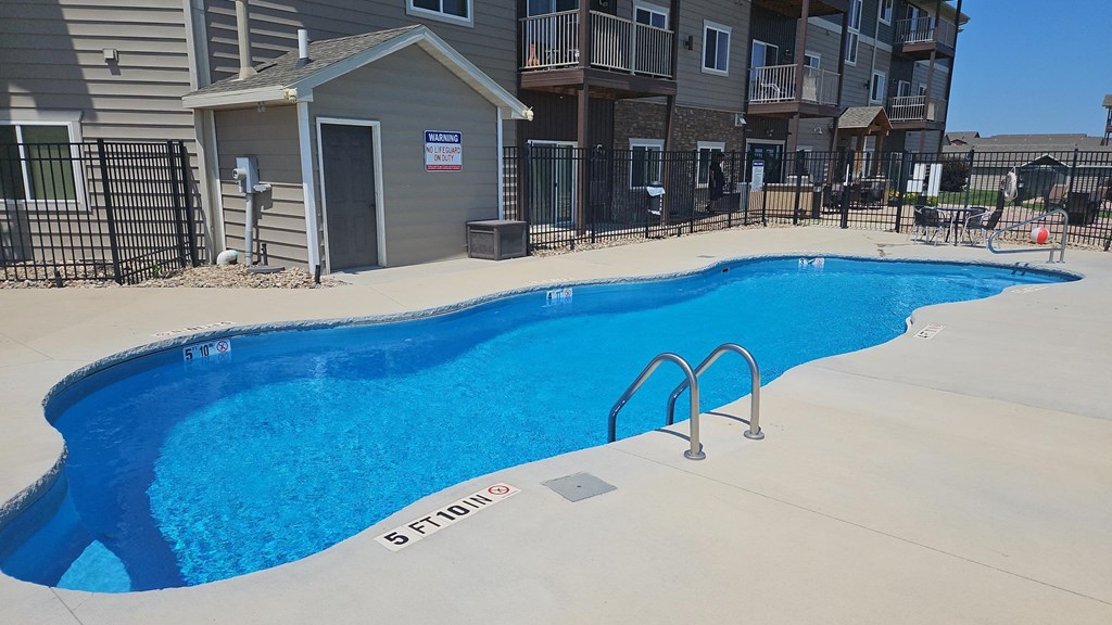 a swimming pool in front of an apartment building