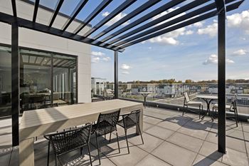 A patio with a table and chairs is covered by a roof.