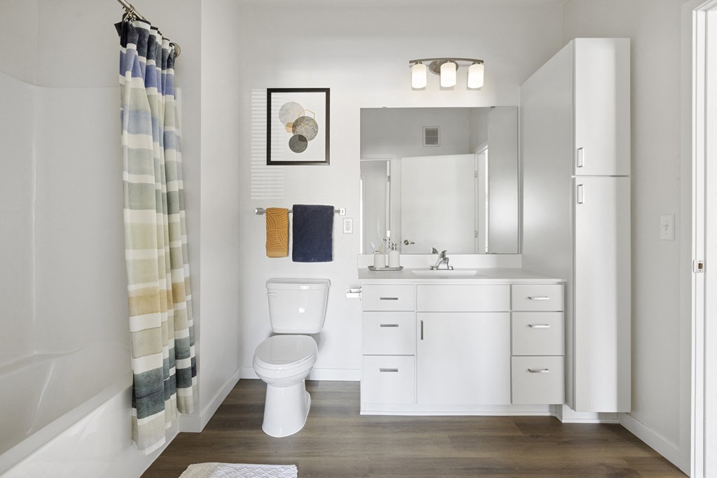 a bathroom with a toilet sink and shower and a mirror