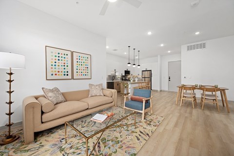 A living room with a tan couch, a coffee table, and a rug with a floral pattern.