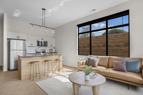 A modern living room with a bar area and a couch at The Whitney in Salt Lake City, Utah.