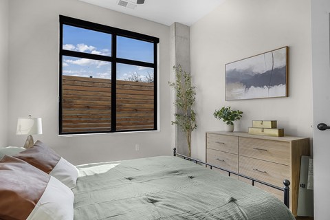 A bedroom with a large bed and a painting on the wall.