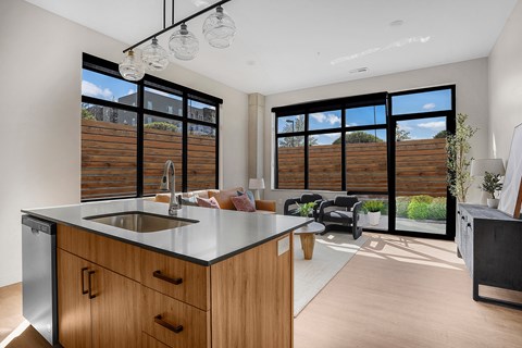 A modern kitchen with wooden cabinets and a stainless steel sink.