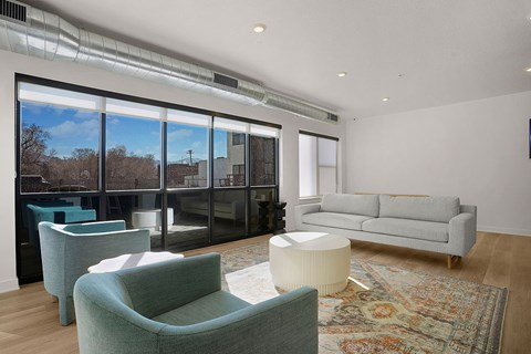A living room with a grey couch and a green chair.
