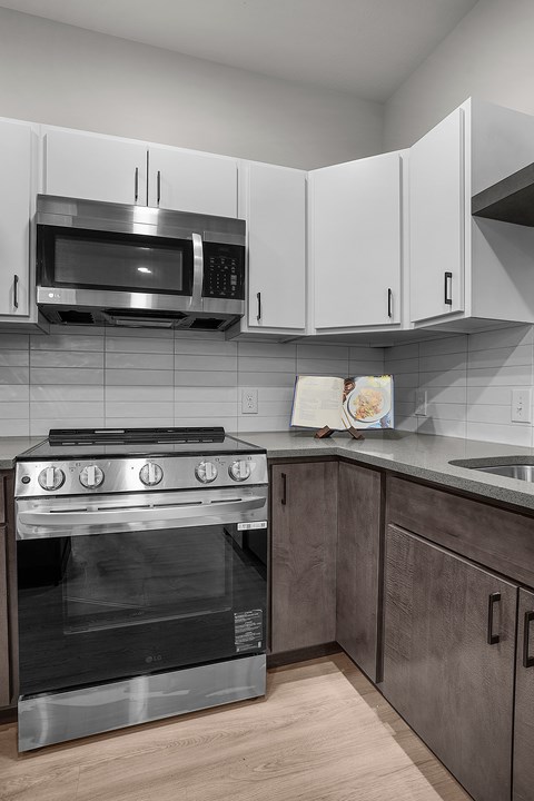 A modern kitchen with a stainless steel oven and microwave.