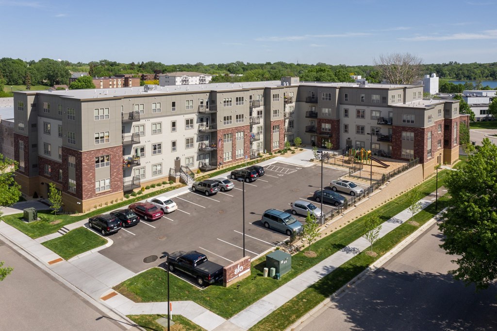 an aerial view of an apartment complex with cars parked in a parking lot