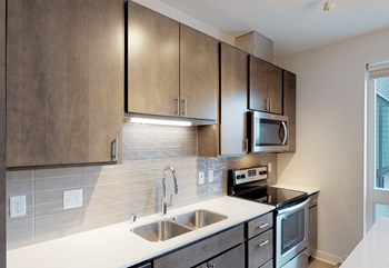 an empty kitchen with stainless steel appliances and wooden cabinets